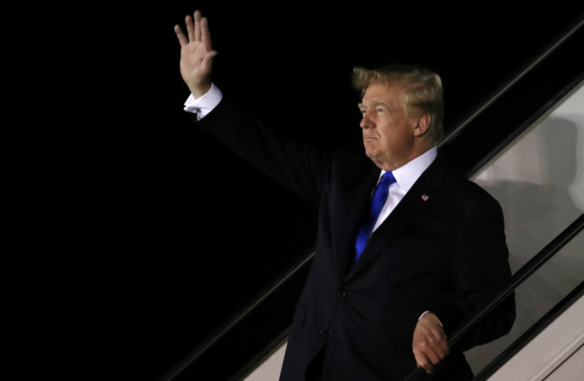 U.S. President Donald Trump waves as he disembarks Air Force One after arriving in Singapore June 10, 2018 (photo credit: JONATHAN ERNST / REUTERS)