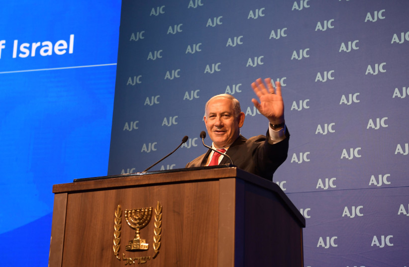 Prime Minister Benjamin Netanyahu addresses the AJC Global Forum, June 10, 2018 (credit: AMOS BEN GERSHOM, GPO)