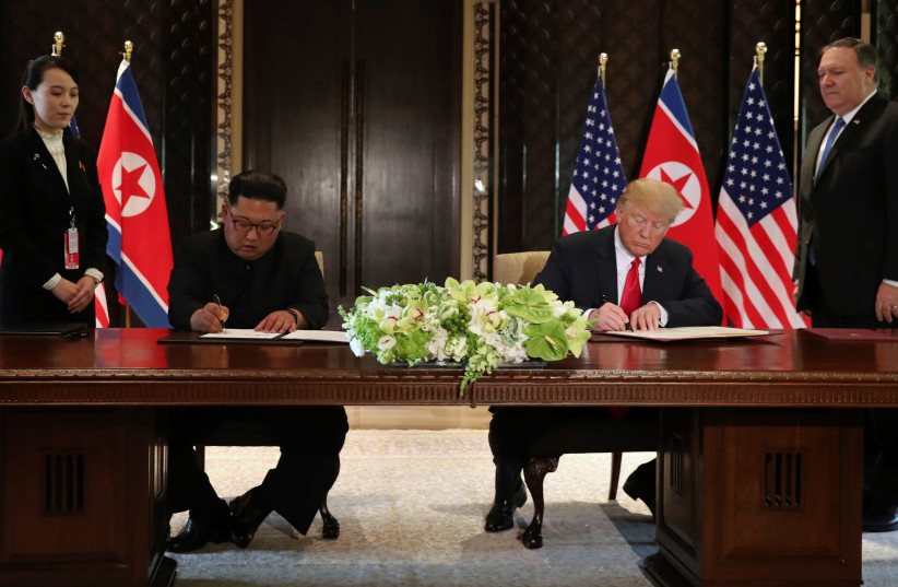 U.S. President Donald Trump and North Korea's leader Kim Jong Un sign documents that acknowledge the progress of the talks and pledge to keep momentum going, after their summit at the Capella Hotel on Sentosa island in Singapore June 12, 2018. (photo credit: JONATHAN ERNST / REUTERS)