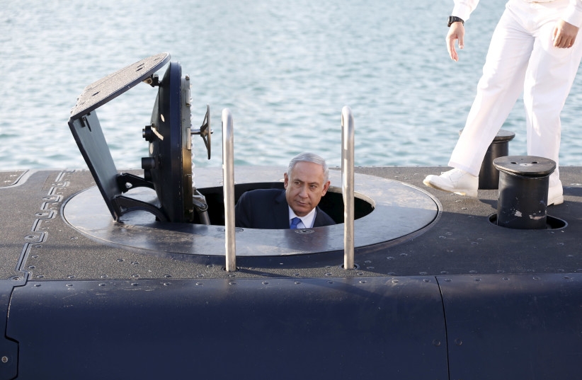 Prime Minister Benjamin Netanyahu climbs out after a visit inside the Rahav, the fifth submarine in the fleet, after it arrived in Haifa's port (credit: BAZ RATNER/REUTERS)