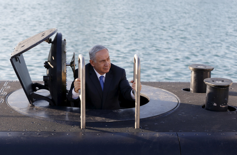 Prime Minister Benjamin Netanyahu climbs out of the 'Rahav,' the fifth submarine in the navy's fleet, in 2017 (photo credit: BAZ RATNER/REUTERS)