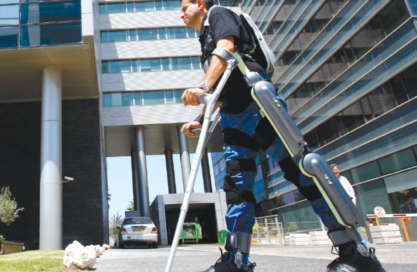 A MAN walks using ReWalk, an electronic exoskeleton, at a development center in Haifa (photo credit: BAZ RATNER/REUTERS)
