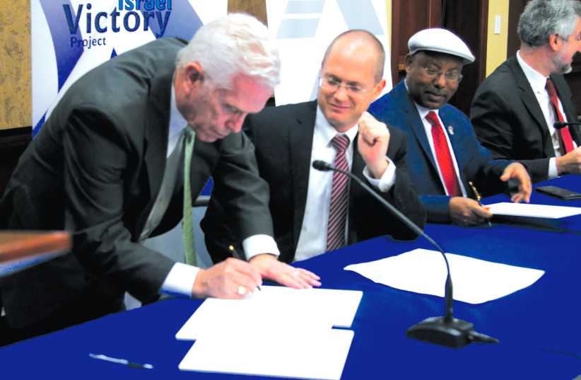 CONGRESSMAN BILL JOHNSON, one of the co- chairs of the Congressional Israel Victory Caucus,  signs the joint declaration with Knesset Israel  Victory Caucus co-chairs MKs Oded Forer and  Avraham Neguise, and Prof. Daniel Pipes (in the  background), at a joint meeting of the CIVC and  the KIVC in Con (photo credit: Courtesy)