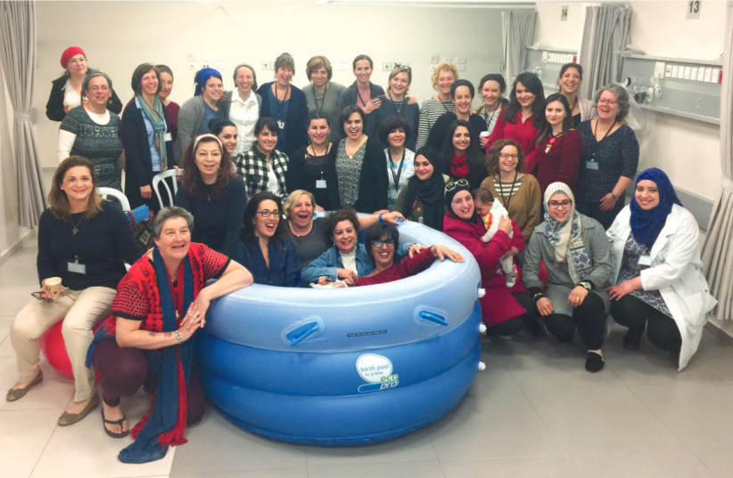 STAFF FLANK (and get comfortable in) one of the hospital’s new birthing pools (photo credit: SISTER VALENTINA)
