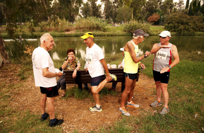 Senior Israelis chat and warm up before a running session as they take part in games for people over 65 years old. (photo credit: BAZ RATNER/REUTERS)