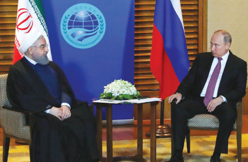 RUSSIAN PRESIDENT Vladimir Putin meets with Iranian President Hassan Rouhani on the sidelines of the Shanghai Cooperation Organisation Summit in Qingdao, China, on June 9 (photo credit: REUTERS)
