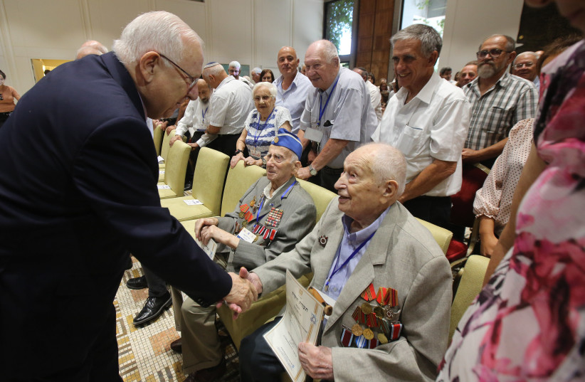 President Reuven Rivlin shakes hands with a man who is 100 years old  (photo credit: MARC ISRAEL SELLEM/THE JERUSALEM POST)