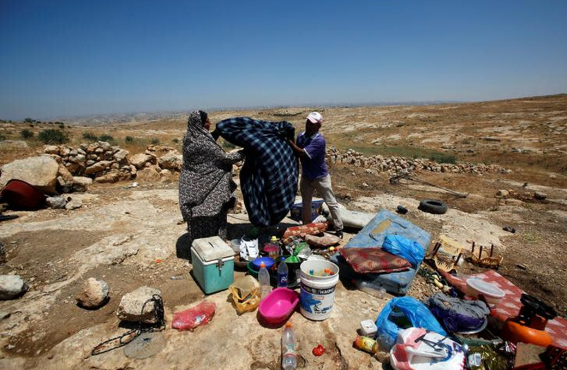  Palestinians check their belongings after the army removed their tent at Susiya village, July 5, 2018 (photo credit: REUTERS/MUSSA QAWASMA)