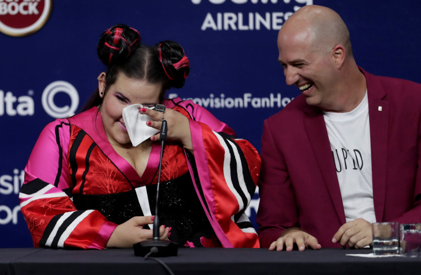 Israel's Netta, sitting alongside composer Doron Medalie, attends the news conference after winning the Grand Final of Eurovision Song Contest 2018, May 13, 2018. (photo credit: REUTERS/RAFAEL MARCHANTE)