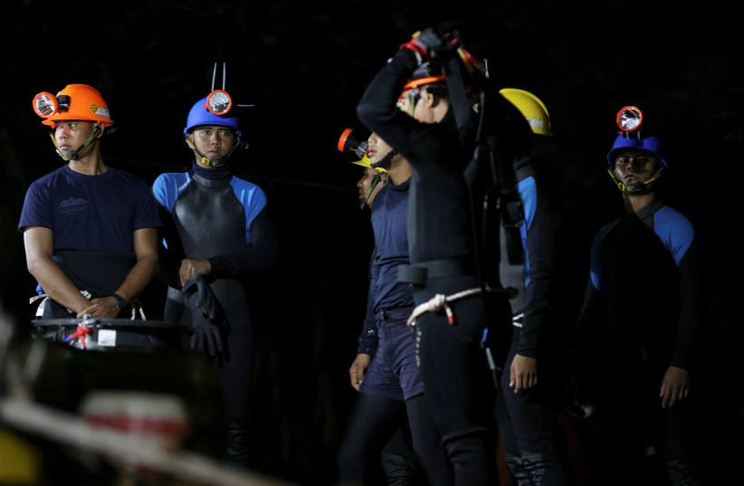 Thai divers gather before they enter to the Tham Luang cave, where 12 boys and their soccer coach are trapped, in the northern province of Chiang Rai, Thailand, July 6, 2018.  (photo credit: REUTERS/ATHIT PERAWONGMETHA)