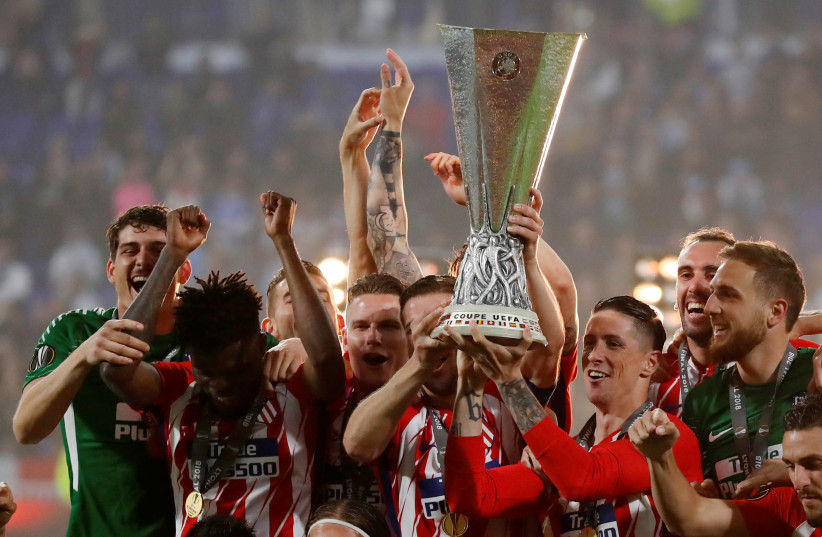 Atletico Madrid's Gabi and Fernando Torres lift the trophy as they celebrate winning the Europa League (photo credit: REUTERS/PETER CZIBORRA)