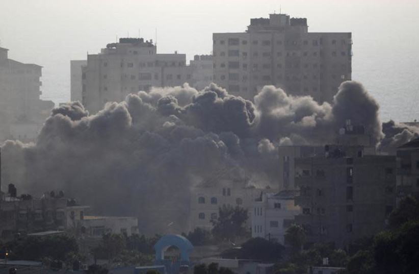 Smoke rises following an Israeli strike on a building in Gaza City July 14, 2018 (photo credit: AHMED ZAKOT / REUTERS)