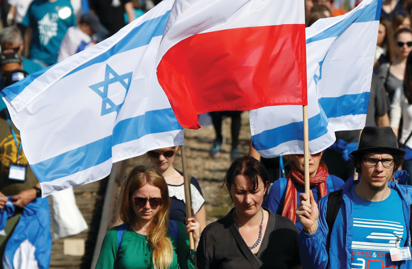 Polish and Israeli flags at a march next to Auschwitz in April (credit: REUTERS)