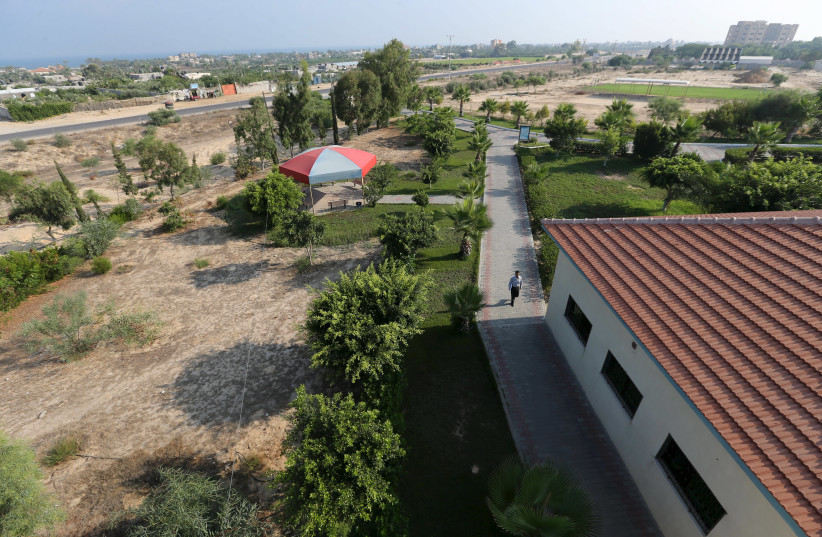A Palestinian security guard walks at a university in Khan Younis in the southern Gaza Strip August 6, 2015. (photo credit: IBRAHEEM ABU MUSTAFA / REUTERS)