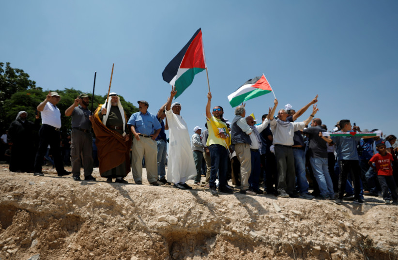 Palestinians attend a protest against Israel's plans to demolish the Bedouin village of Khan al-Ahmar, in the West Bank.  (photo credit: MOHAMAD TOROKMAN/REUTERS)