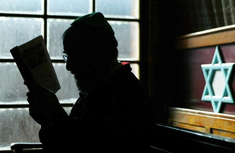 Irish Jew Raphael Siev who is part of Ireland's dwindling Jewish community is seen reading a book in this photo taken on March 2, 2003 (credit: REUTERS/PAUL MCERLANE)