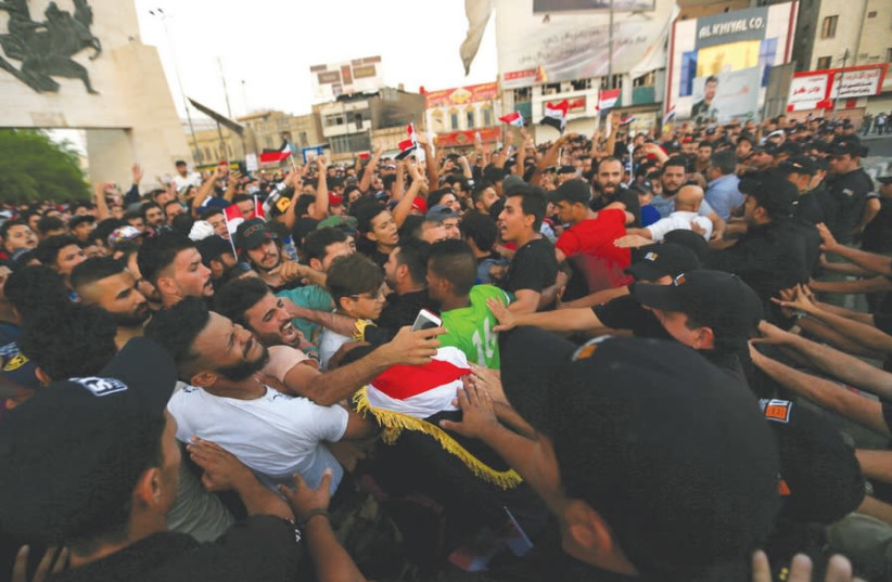 PROTESTERS ARE pushed back by Iraqi security forces during a protest at Tahrir Square in Baghdad, July 2018 (photo credit: THAIER AL-SUDANI/REUTERS)