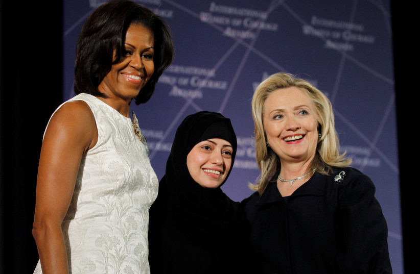 US Secretary of State Hillary Clinton and First lady Michelle Obama (L) congratulate Samar Badawi of Saudi Arabia during the State Department's 2012 International Women of Courage Award winners ceremony in Washington March 8, 2012.  (photo credit: REUTERS/GARY CAMERON)