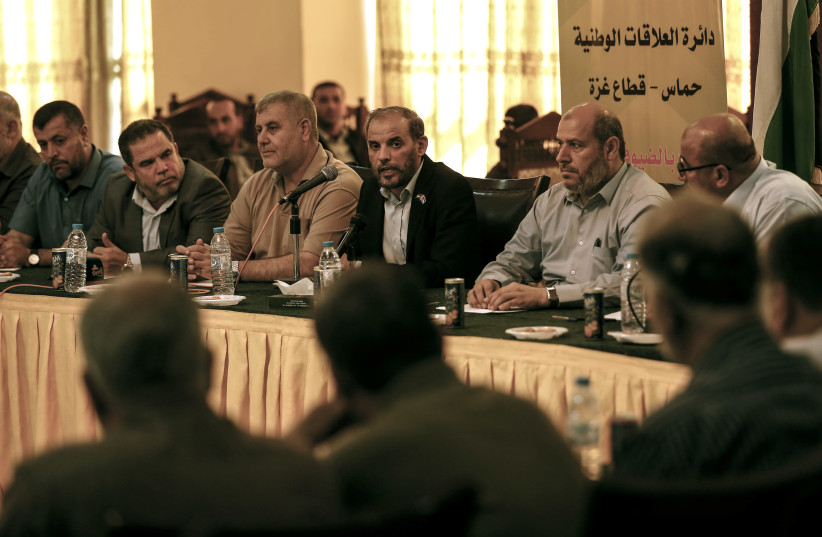 Hamas officials Husam Badran (C) and Khalil al-Hayya (2nd-R) attend a meeting with Palestinian factions in Gaza City on August 5, 2018 (photo credit: MAHMUD HAMS / AFP)
