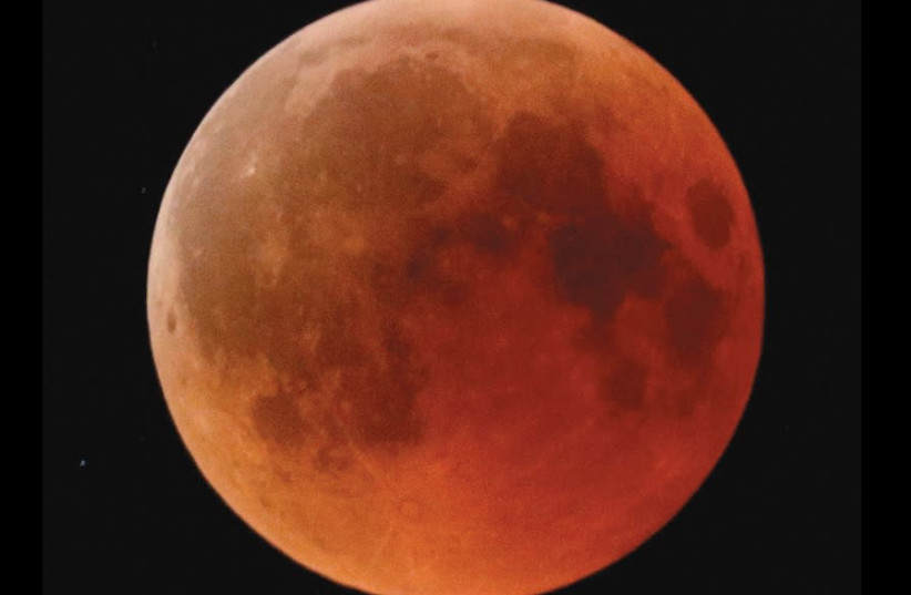 A blood moon rises, as seen from the Israeli city of Ashkelon, on July 27, 2018 (photo credit: AMIR COHEN/REUTERS)