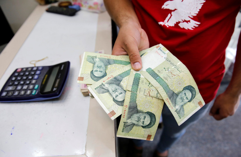 A vendor inspects Iranian rials on Wednesday at a currency exchange shop in Baghdad (photo credit: KHALID AL MOUSILY / REUTERS)