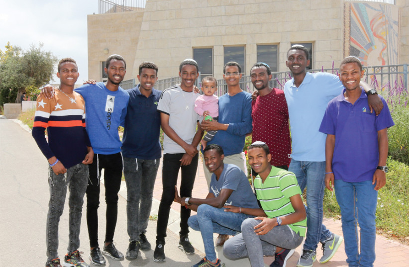 The eight Ethiopian young men who came to Israel to study Torah, with their counselor (holding baby) and Sintayehu Shaparou (fourth from left), the Ethiopian student who came here earlier this year to participate in the International Bible Quiz. (photo credit: MARC ISRAEL SELLEM)
