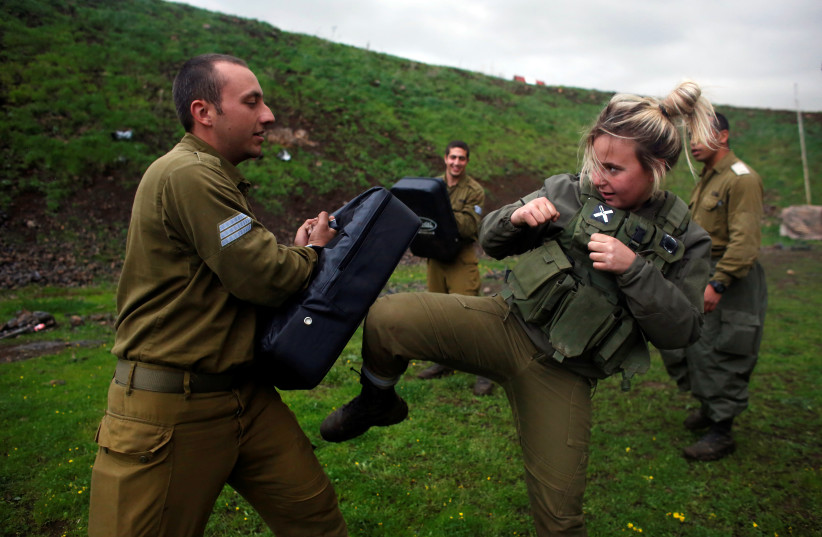 A female Israeli soldier takes part in a training session in Krav Maga at a military base in the Golan Heights, March 1, 2017 (photo credit: NIR ELIAS / REUTERS)