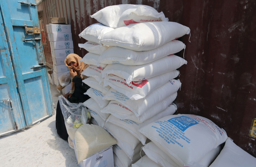 A PALESTINIAN woman sits next to bags of UNRWA flour (photo credit: REUTERS)