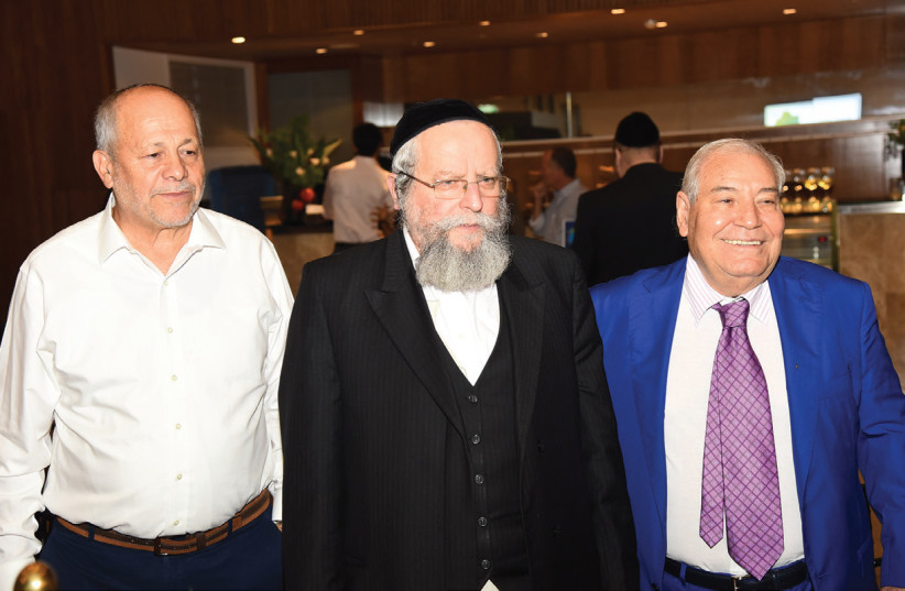 RABBI ELIMELECH FIRER (center), founder of Ezra Lemarpeh, is flanked by his assistant Kalman Shraiber (left), and tribute chairman Ami Sagi (right) last week. (photo credit: MORAG BITAN)