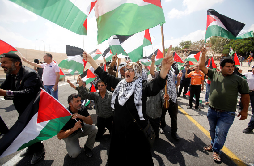 Palestinians take part in a protest against the Israeli planned demolition of the illegal Bedouin squatter village of Khan al-Ahmar, September 7, 2018. (photo credit: MUSSA QAWASMA / REUTERS)