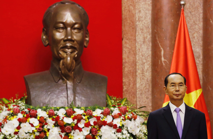 Vietnam President Tran Dai Quang in front of Ho Chi Minh statue and Vietnamese flag before meeting, Presidential Palace, Hanoi, 2018 (photo credit: KHAM / REUTERS)