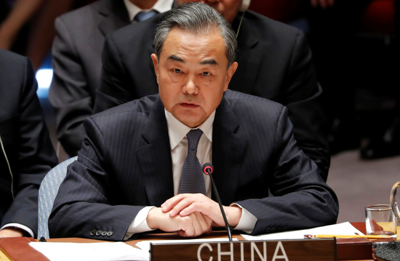 China's Foreign Minister Wang Yi listens to US President Donald Trump address a UN Security Council meeting during the 73rd session of the United Nations General Assembly at UN headquarters in New York, US, September 26, 2018.  (photo credit: REUTERS/CARLOS BARRIA)
