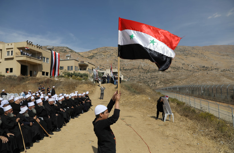 Druze people take part in a rally in Majdal Shams near the ceasefire line between Israel and Syria in the Israeli occupied Golan Heights, overlooking the other side of the border October 6, 2018  (photo credit: AMMAR AWAD / REUTERS)