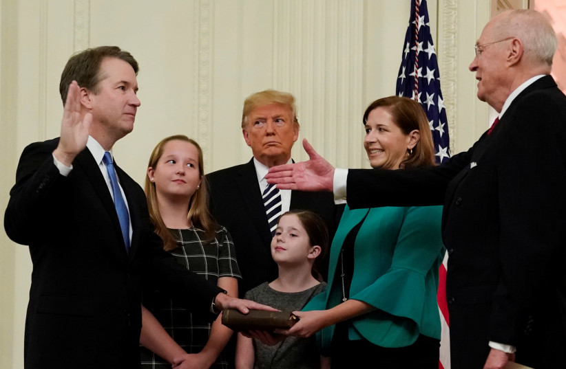 U.S. Supreme Court Associate Justice Brett Kavanaugh is congratulated by retired Justice Anthony Kennedy, as his wife Ashley and daughters Liza and Margaret, and President Donald Trump look on during his ceremonial public swearing-in at the East Room of the White House in Washington, U.S. (photo credit: JONATHAN ERNST / REUTERS)