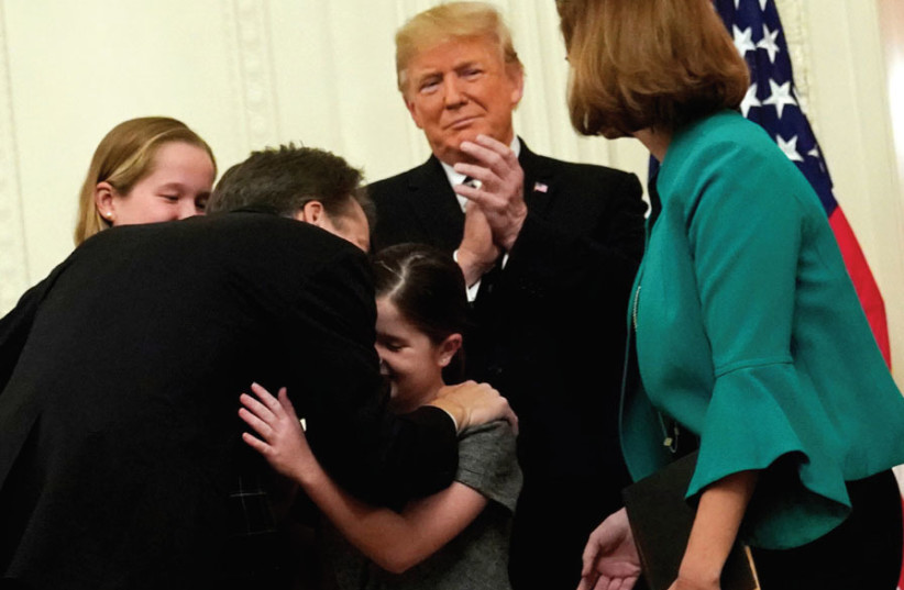 US SUPREME COURT Associate Justice Brett Kavanaugh hugs daughters Liza and Margaret during his ceremonial public swearing-in, as US President Donald Trump and Kavanaugh’s wife Ashley look on, in the White House in Washington on October 8. (photo credit: REUTERS)