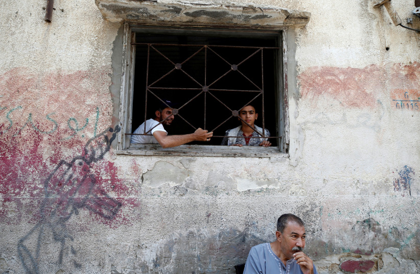 Palestinians look out of their home at Al-Shati refugee camp in Gaza City September 3, 2018 (photo credit: REUTERS/MOHAMMED SALEM)