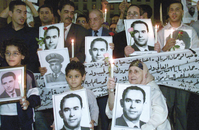 MOROCCANS HOLD portraits of former Moroccan opposition leader Mahdi Bin Barka during a candle-lit gathering in Rabat in 2002. (photo credit: REUTERS)
