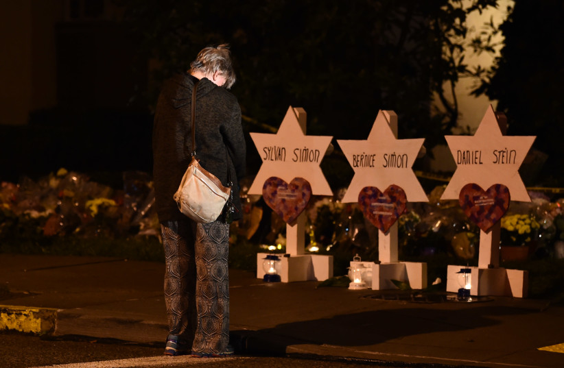 A woman bows her head in front of a memorial on October 28, 2018, at the Tree of Life synagogue after a shooting there left 11 people dead in the Squirrel Hill neighborhood of Pittsburgh on October 27 (photo credit: BRENDAN SMIALOWSKI / AFP)