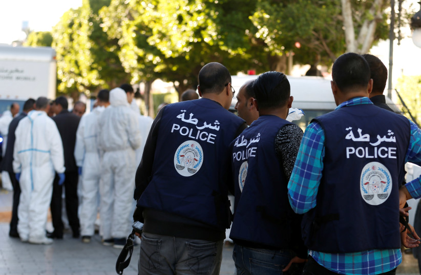 Policemen secure the area as forensic experts work near the site of an explosion in the center of the Tunisian capital (photo credit: ZOUBEIR SOUISSI / REUTERS)