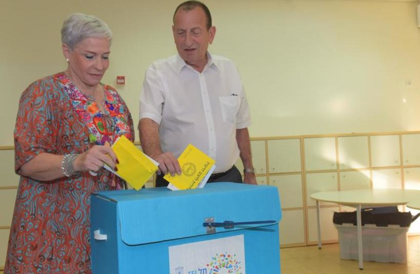 Incumbent Tel Aviv mayor and candidate Ron Huldai and his wife cast their votes on Tuesday, October 30, 2018 (photo credit: AVSHALOM SASSONI)