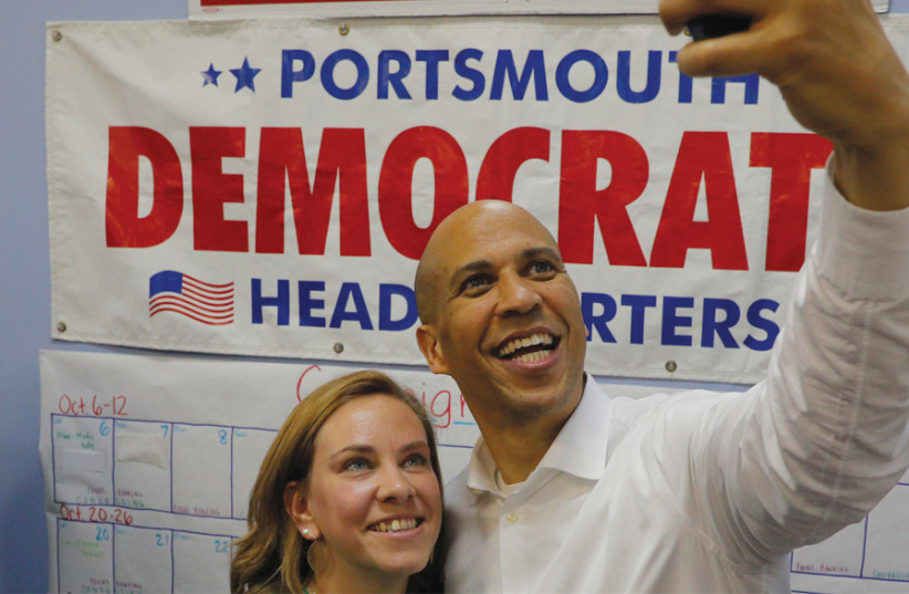 US SENATOR Cory Booker (D-New Jersey) takes a selfie after encouraging volunteer campaign canvassers ahead of the midterm elections, in Portsmouth, New Hampshire, on October 28. (photo credit: REUTERS)