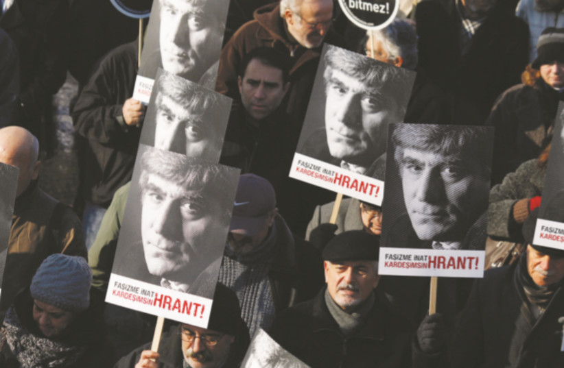 FRIENDS OF slain Turkish-Armenian journalist Hrant Dink march with posters bearing the image of Dink during a demonstration near a courthouse in Istanbul in 2012 (photo credit: MURAD SEZER/REUTERS)