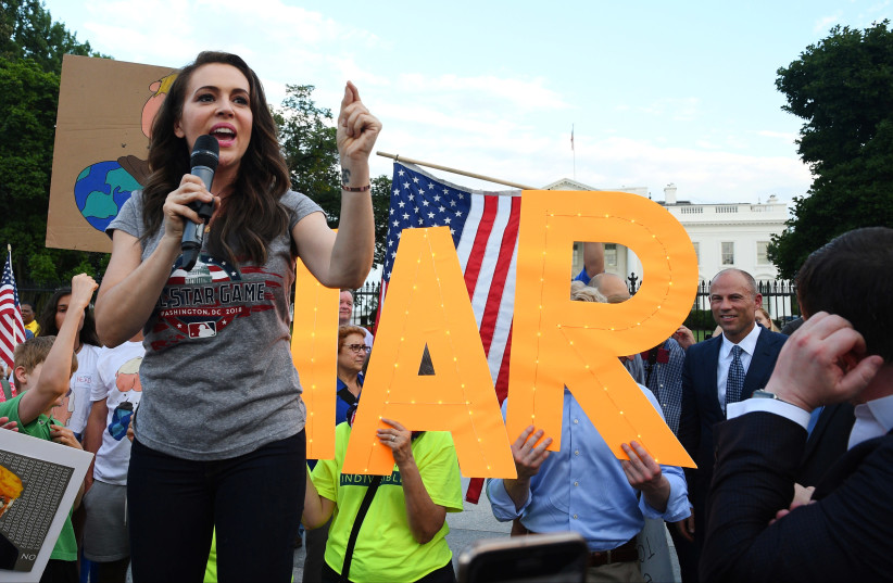 Actor Alyssa Milano makes remarks as Attorney Michael Avenatti listens, at a protest outside the White House in Washington, July 17, 2018 (photo credit: MARY F. CALVERT / REUTERS)