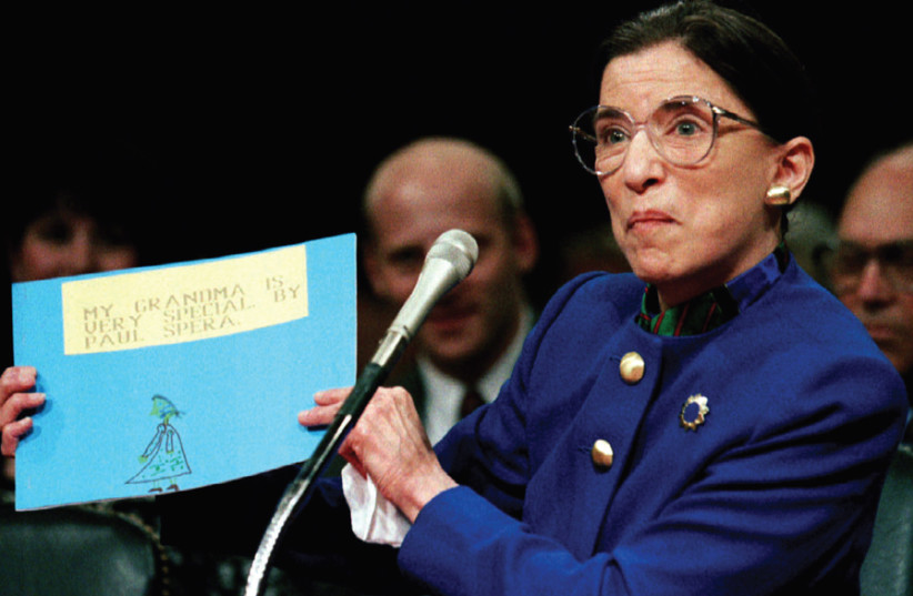 RUTH BADER GINSBURG appears before the Senate Judiciary Committee for her Supreme Court confirmation hearing in 1993 – holding a sign made by her grandson. (photo credit: GARY HERSHORN/REUTERS)