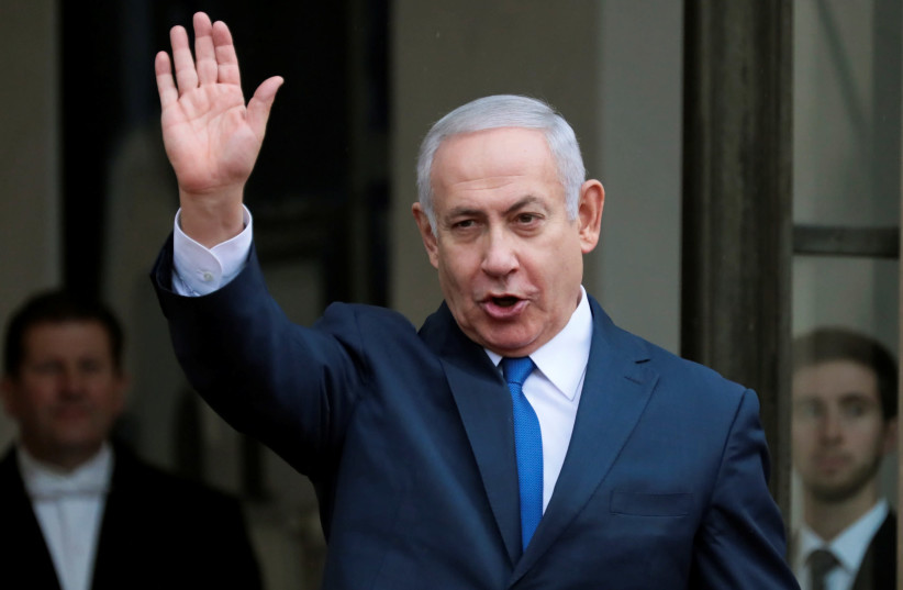 Israeli Prime Minister Benjamin Netanyahu waves as he arrives at the Elysee Palace after the commemoration ceremony for Armistice Day, 100 years after the end of World War One, in Paris, France, November 11, 2018 (photo credit: REINHARD KRAUSE/REUTERS)