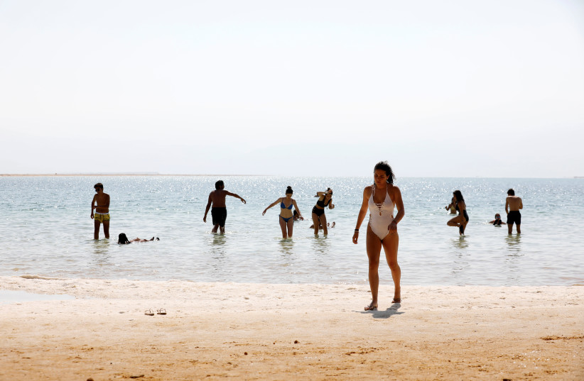Tourists bathe at the shore of the Dead Sea, Israel July 17, 2018. Picture taken July 17, 2018. (photo credit: AMIR COHEN/REUTERS)