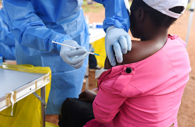  Congolese health worker administers Ebola vaccine to a woman who had contact with an Ebola sufferer in the village of Mangina in North Kivu province of the Democratic Republic of Congo, August 18, 2018 (photo credit: OLIVIA ACLAND/REUTERS)