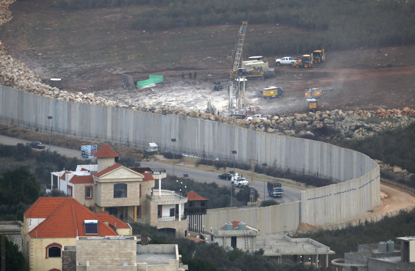 This picture taken on December 4, 2018 near the northern Israeli town of Misgav Am, shows Israeli machinery operating machinery (R) near the border wall with Lebanon (photo credit: JALAA MAREY/AFP)