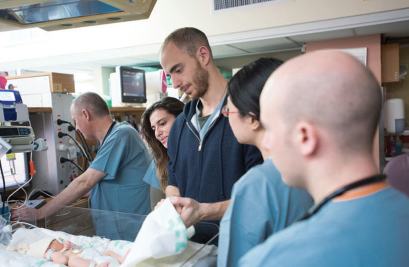 Class 2019’s fourth year MSIH student Jonah Cohen (his back to the camera) together with fellow classmates (right to left) Jixi He, Steven Zilberman and Elena Soukhov doing the rounds with Soroka neonatologist Dr. Justin Richardson (looking at monitor) (photo credit: DAN MACHLIS)