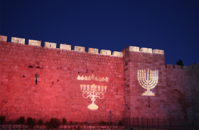 IMAGES OF hanukkiot decorate Jerusalem’s Old City walls: ‘By lighting candles, we declare that there is no darkness that Jewish faith cannot overcome.’ (photo credit: MARC ISRAEL SELLEM)